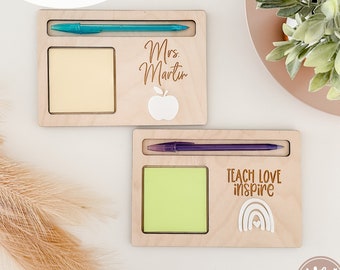 May include: Two wooden notepads with a pen holder and a space for a sticky note. The top notepad has the text "Mrs. Martin" and an apple. The bottom notepad has the text "Teach Love Inspire" and a rainbow.
