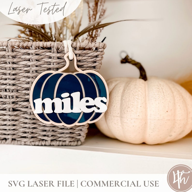 May include: A blue and white pumpkin-shaped ornament with the word "miles" written in white letters. The ornament is hanging from a wicker basket.