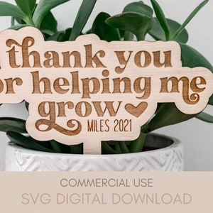 May include: A wooden plant stake with the text "thank you for helping me grow" and a small heart. The text "MILES 2021" is also included on the stake.