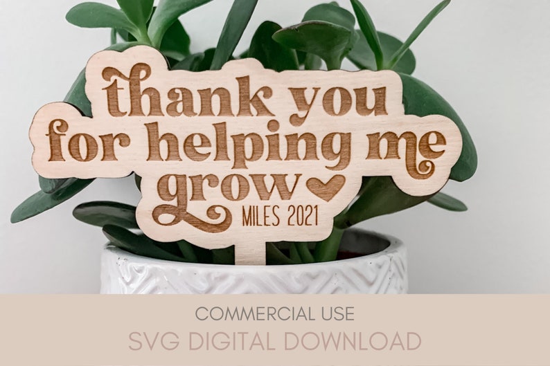 May include: A wooden plant stake with the text "thank you for helping me grow" and a small heart. The text "MILES 2021" is also included on the stake.