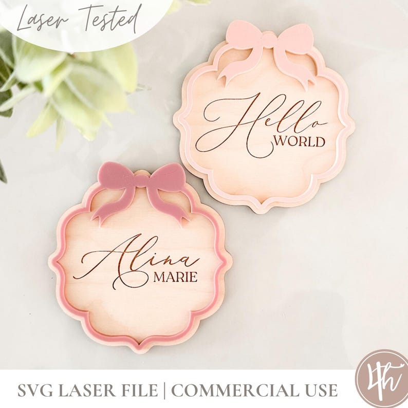 Puede incluir: Dos letreros de madera cortados con l&aacute;ser con un dise&ntilde;o de lazo rosa. El letrero superior dice "Hello World" y el letrero inferior dice "Alina Marie".