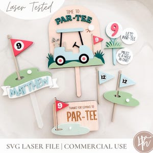 May include: A collection of golf-themed wooden cake toppers featuring a light blue golf cart, green putting greens, red and blue flags with numbers 9 and 12, and circular signs with text including Time to Par-Tee and Miles is a Hole in One.