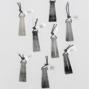 May include: Seven black and white crystal pendants with black cords. Each pendant has a label with the text "C. Rufilado 13124".