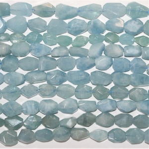 Puede incluir: Una hebra de cuentas de piedra preciosa de aguamarina azul claro. Las cuentas son facetadas y tienen una forma ligeramente irregular.