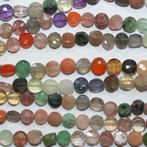 Può includere: File di perline colorate di pietre preziose in varie forme e dimensioni. Le perline mostrano una gamma di colori, tra cui viola, arancione, verde e rosa. Le perline sono infilate, pronte per la creazione di gioielli.