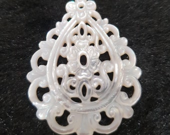 May include: A white, intricately carved, mother-of-pearl pendant in the shape of a teardrop with a floral design.