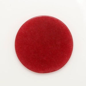 Peut inclure: Un dessous de verre rond en pierre, de couleur rouge, lisse et poli.