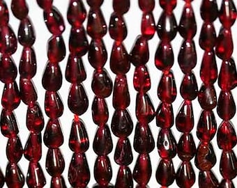 16 po. Perles lisses grenat 7 x 5 mm. Fil d'environ 36 cm
