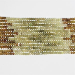 May include: A strand of green and brown faceted gemstone beads. The beads are small and round, and they are strung on a clear thread.