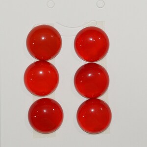 Könnte beinhalten: Sechs runde, rote Glascabochons. Die Cabochons sind glatt und glänzend.