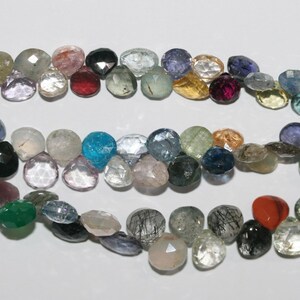 Puede incluir: Una hebra de cuentas de piedras preciosas facetadas en varios colores, incluyendo transparente, azul, verde, rosa y marrón. Las cuentas son todas aproximadamente del mismo tamaño y forma, y están enhebradas en un hilo transparente.
