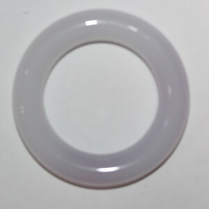 May include: A light purple jade bangle bracelet. The bangle is smooth and polished.