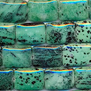 Può includere: Una collana di perline rettangolari di pietra preziosa verde e nera. Le perline hanno un motivo maculato e una finitura leggermente iridescente.