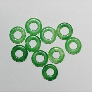 May include: Ten green jade ring beads with a smooth, polished finish. The rings are approximately 1 inch in diameter.