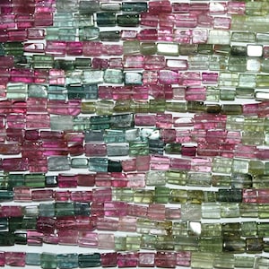 Può includere: Una collana di perle di turmalina multicolori. Le perle sono rettangolari e presentano una varietà di sfumature di rosa, verde e blu.