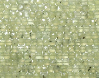 May include: A close-up of a strand of light green square-shaped beads with a faceted finish. The beads have a subtle shimmer and are made of natural stone.