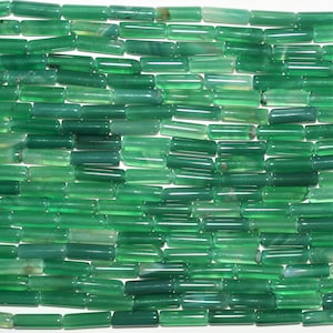 Può includere: Una collana di perline di agata verde, ogni perla è un cilindro liscio e lucido.