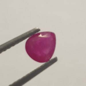 Peut inclure: Une pierre précieuse rose vif en forme de cœur, tenue par une pince.