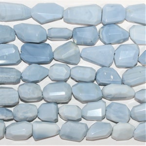 Può includere: Una collana di perle di opale naturale sfaccettate di colore blu chiaro. Le perle sono di forma irregolare e hanno una finitura liscia e lucida.