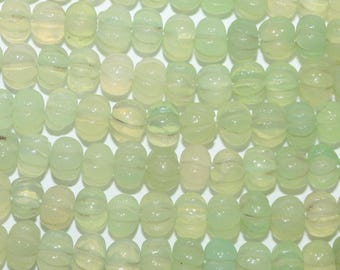May include: A collection of pale mint green beads arranged in parallel rows. Each bead features a translucent, rounded, and ribbed pumpkin-like shape with a smooth, polished surface, creating a uniform and repetitive pattern across the entire frame.