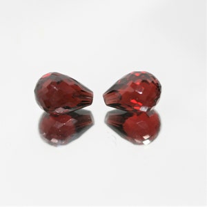 Par granat halvborrade fasetterade droppar 10 x 7 mm.