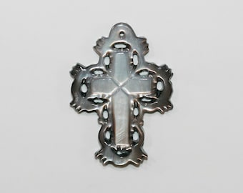May include: A silver cross pendant with a white mother of pearl inlay. The cross has a delicate, intricate design.