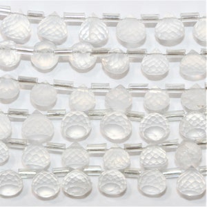 Puede incluir: Una hebra de cuentas de cuarzo transparente facetado en forma de lágrima con cuentas espaciadoras plateadas.