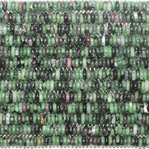 Peut inclure: Un brin de perles de pierres précieuses vertes, noires et roses. Les perles sont rondes et ont une finition lisse et polie.