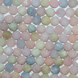 Puede incluir: Una hebra de cuentas de piedras preciosas facetadas en varios tonos de rosa, azul, verde y blanco. Las cuentas están enhebradas en un hilo rosa.