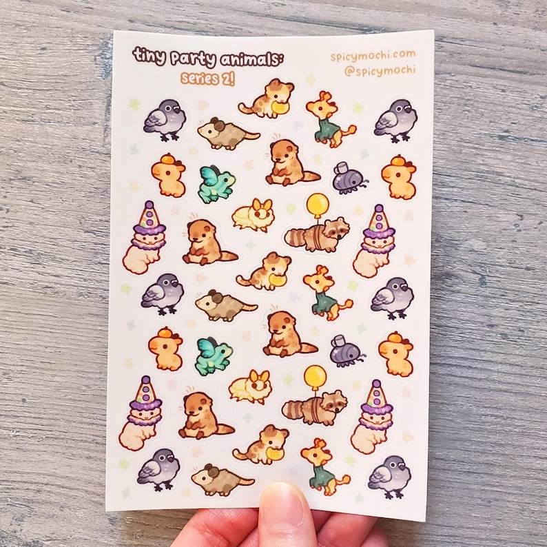 May include: A sheet of stickers featuring tiny party animals in various poses and costumes. The stickers are on a white background with a light blue border. The text "tiny party animals: series 2!" is at the top of the sheet. The text "spicymochi.com @spicymochi" is in the top right corner.