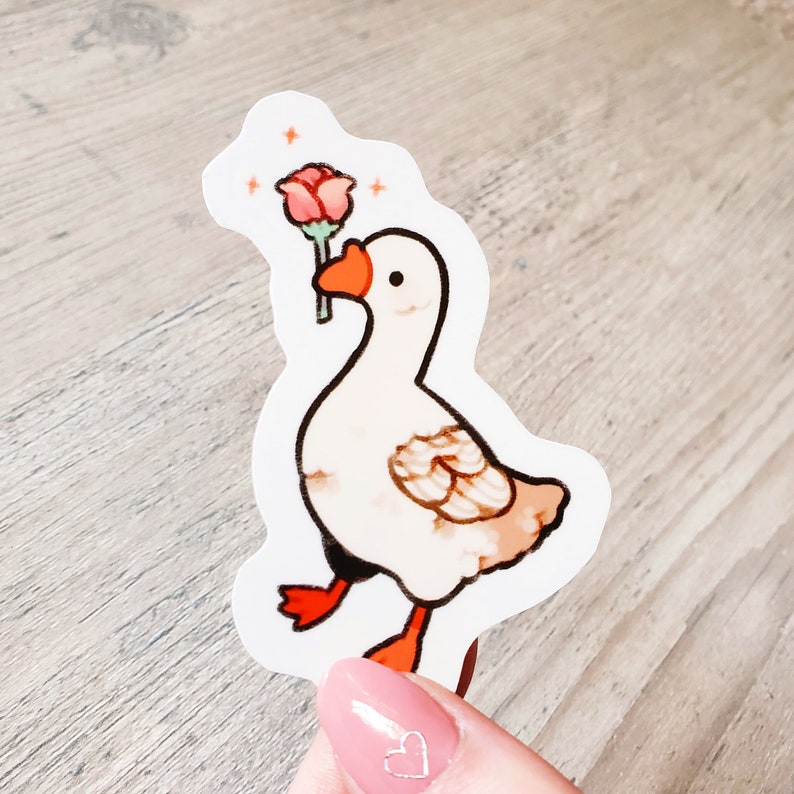 May include: A white goose sticker with a pink rose in its beak. The goose is walking with its legs outstretched. The sticker is on a white background.