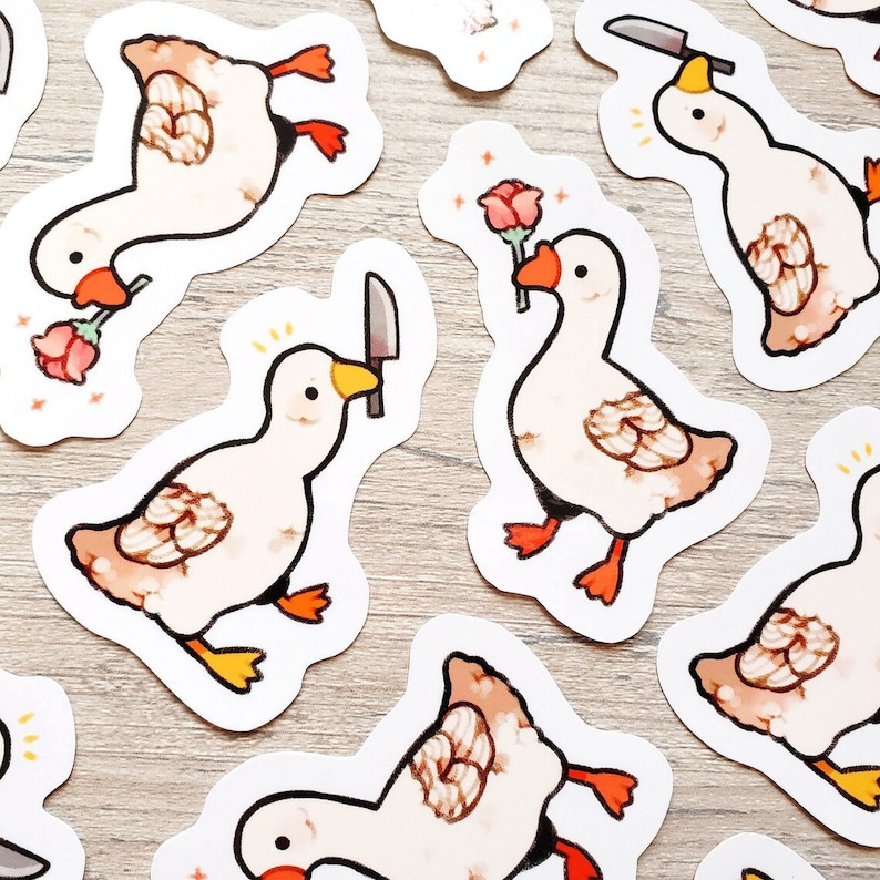May include: A set of nine stickers featuring cartoon geese with various expressions. Some geese are holding knives, while others are holding roses. The stickers are white with a light brown background.