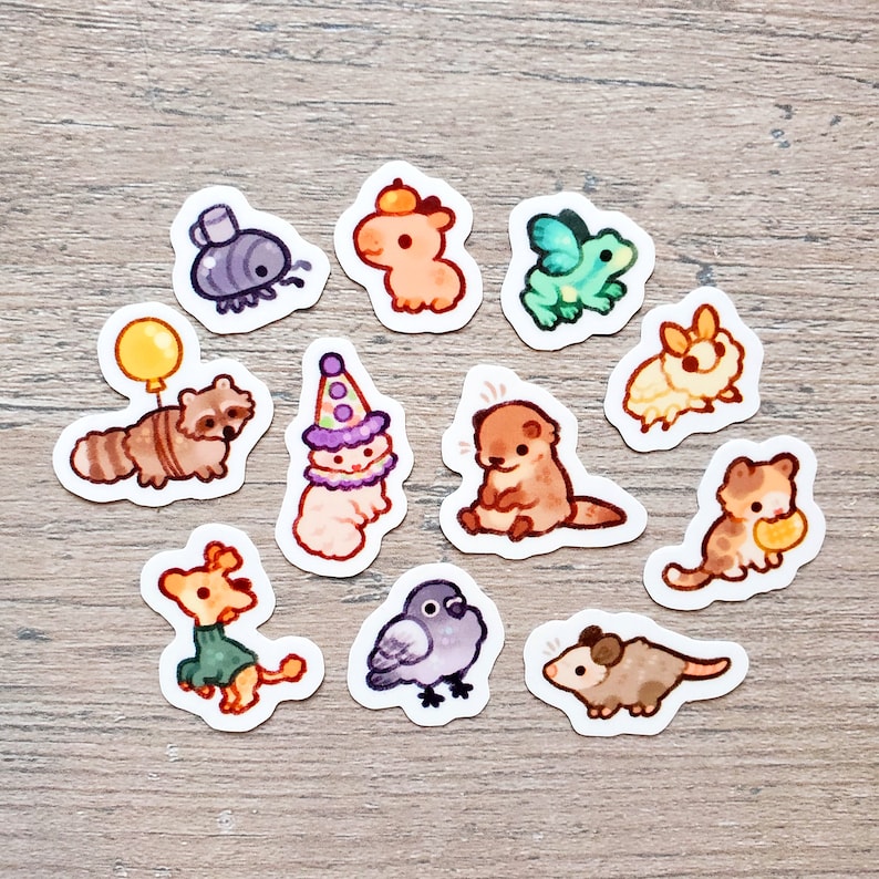 May include: A set of 11 colorful animal stickers featuring a raccoon, otter, cat, bird, frog, and more. The stickers are perfect for adding a touch of whimsy to journals, laptops, water bottles, and other surfaces.