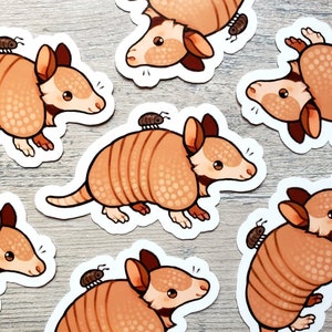May include: A set of nine stickers featuring cartoon armadillos with various poses and expressions. Each armadillo is brown with a white underbelly and has a small bug on its back. The stickers are perfect for adding a touch of whimsy to laptops, water bottles, or journals.