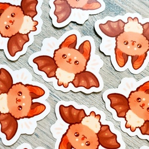 May include: Set of ten cute bat stickers with orange and brown wings and white bodies. The bats have big eyes and are smiling.