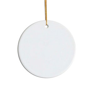 May include: A blank white ceramic ornament with a gold string attached. The ornament is round and has a hole in the top for hanging.