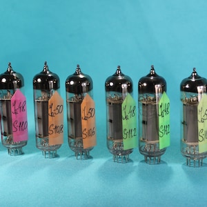May include: Eight glass vacuum tubes with black caps and labels. The labels are pink, green, and orange and have handwritten text on them. The text on the labels includes the numbers 48 and 50, and the letters S-108, S-110, S-112, and S-106.