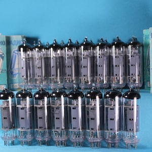 May include: A group of 18 vintage vacuum tubes, all in clear glass with black metal tops, arranged in a row on a blue surface. The tubes are labeled "6n18n" and "RADIO" in Cyrillic script.