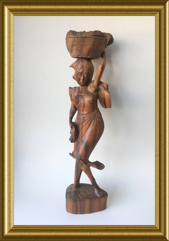 Vintage Asian wood carving: wooden statue of a woman with basket