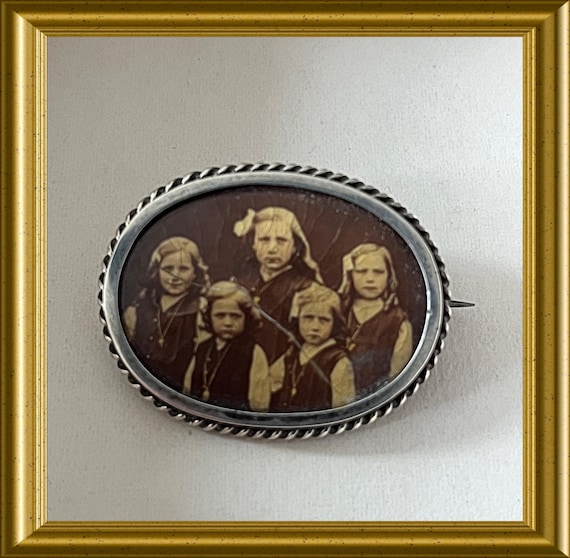 Antique silver photo brooch featuring five children