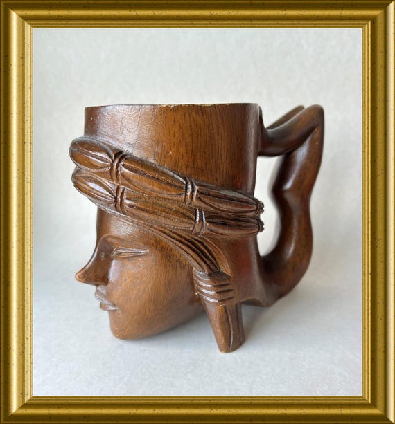 Vintage wooden mug in the shape of a head with a body
