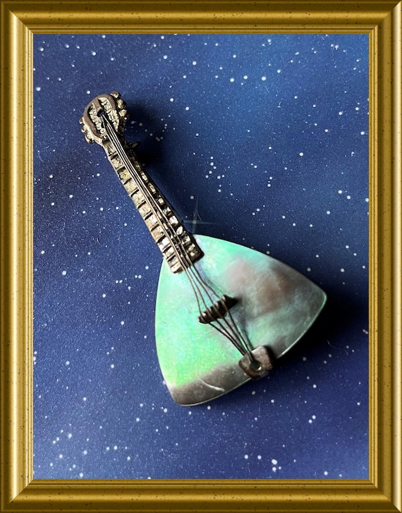 Old brooch with mother-of-pearl: musical instrument, mandolin