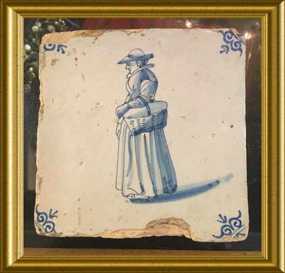 Antique glazed earthenware tile: woman with basket