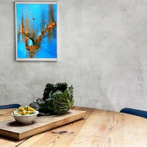 Puede incluir: Una mesa de madera con un bol de ensalada, una cabeza de col y una pintura abstracta enmarcada en la pared detr&aacute;s.