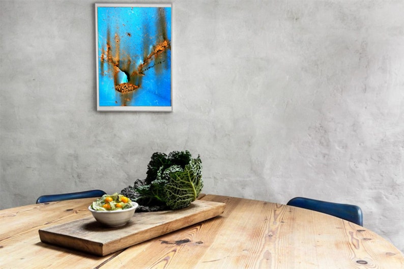 Puede incluir: Una mesa de madera con un bol de ensalada, una cabeza de col y una pintura abstracta enmarcada en la pared detr&aacute;s.