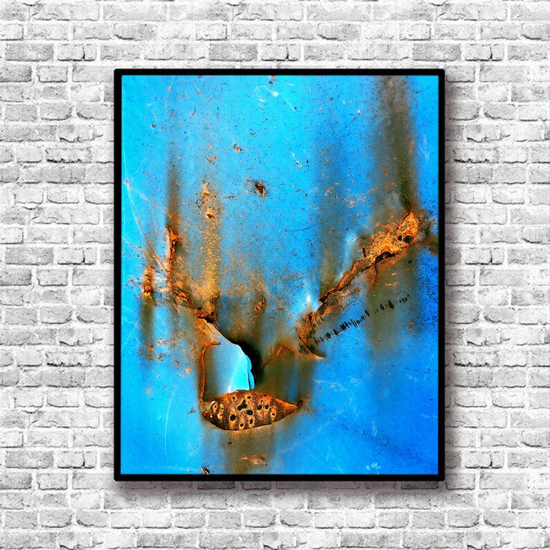 Puede incluir: Impresi&oacute;n de arte abstracto con un esquema de color azul y naranja. La imagen muestra un primer plano de una superficie met&aacute;lica oxidada con una grieta que la atraviesa.