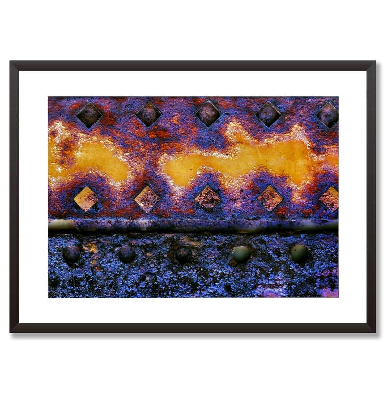 Peut inclure: Gros plan sur une surface m&eacute;tallique rouill&eacute;e avec un motif de trous en forme de diamant. Le m&eacute;tal est un m&eacute;lange de couleurs violettes, orange et jaunes.