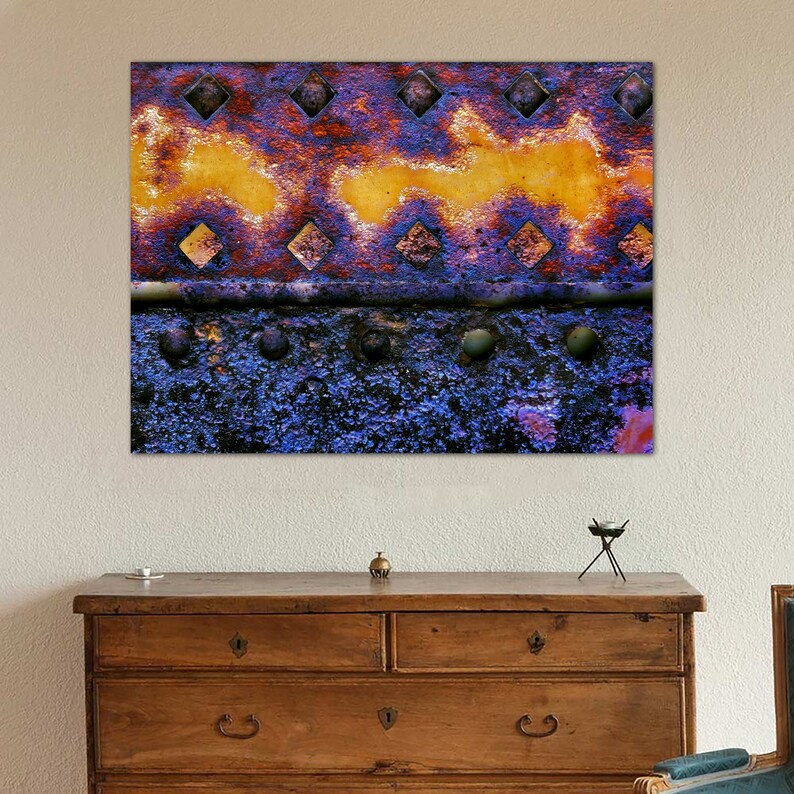 Peut inclure: Gros plan sur une surface m&eacute;tallique rouill&eacute;e avec un motif de peinture jaune et violette. La surface a une texture rugueuse et est recouverte de petits trous.