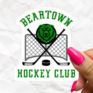 May include: A die-cut sticker featuring a green bear head logo above a grey hockey net and two crossed black hockey sticks with a black puck. The text BEARTOWN HOCKEY CLUB is printed in green, distressed-style capital letters above and below the graphic.