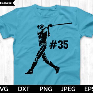 May include: A light blue t-shirt with a black silhouette of a baseball player swinging a bat. The player is wearing a baseball cap and the number "#35" is printed on the shirt.